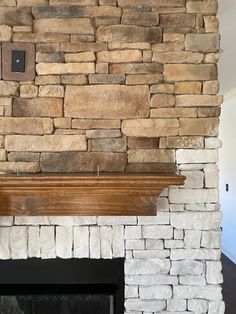 a stone fireplace with a wood mantle