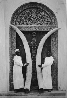 two women standing in front of an ornate door