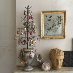 a small christmas tree sitting on top of a table next to a busturine