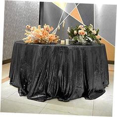 a black table with flowers and candles on it