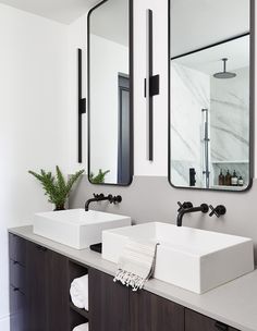 two sinks in a bathroom with mirrors above them