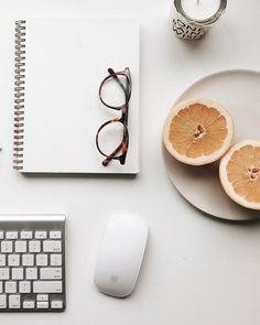 an orange cut in half sitting on top of a desk next to a keyboard and mouse