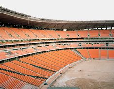 an empty stadium filled with lots of orange seats