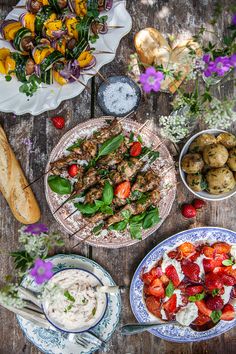 an overhead view of various food items on a wooden table, including salads and appetizers