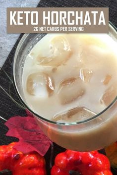 a glass filled with ice sitting on top of a table next to some donuts