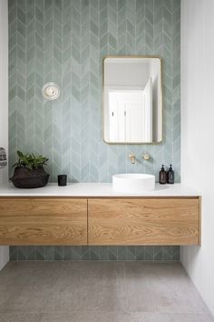 a bathroom with a sink, mirror and wooden cabinet in front of the counter top