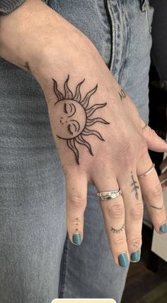 a woman's hand with a sun tattoo on it