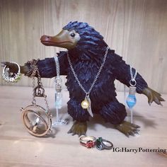 a toy bear that is sitting on a table with other items around it, including rings and necklaces