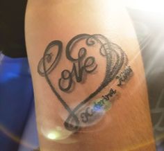 a woman's arm with a tattoo on it that says she is in the shape of a heart