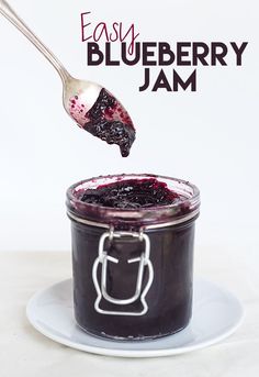 blueberry jam in a glass jar with a spoon sticking out of it and the words easy blueberry jam above it