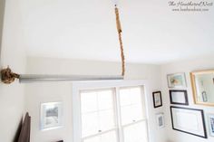 a room with pictures on the wall and a metal pole hanging from it's ceiling