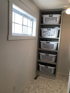 an empty room with several baskets on the shelves