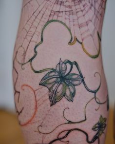 an artistic tattoo on the leg of a woman