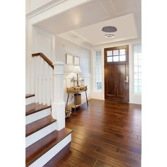 an entryway with wood floors and white walls