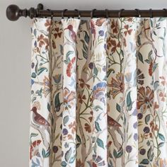 the curtains are hanging on the rod in front of the window with floral designs and birds