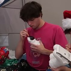 two people in santa hats eating and drinking milkshakes