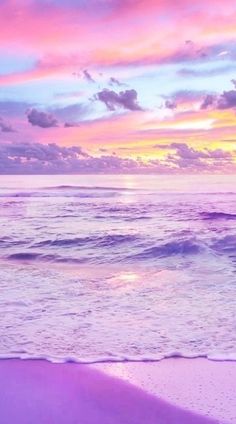 the beach is pink and purple as the sun sets