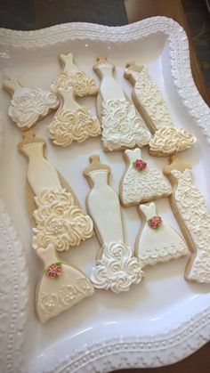 decorated cookies in the shape of wedding gowns on a platter