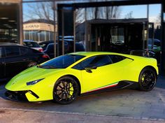 a bright yellow sports car parked in front of a building