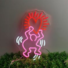 a neon sign with a person holding a heart on it's back and arms