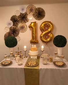 a table topped with a cake covered in frosting and surrounded by gold foil decorations