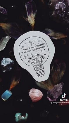 a light bulb surrounded by crystals and stones with the words, how do you think?