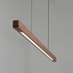 a wooden light fixture hanging from the ceiling with two lights on each side and one in the middle