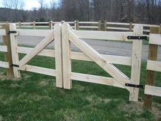 a wooden fence in the middle of a grassy field