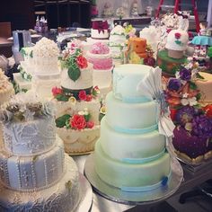 many different types of wedding cakes on display in a store or restaurant room, all decorated and ready to be eaten