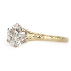 an old - fashioned diamond engagement ring is shown in yellow gold with a center stone