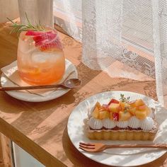 two plates with desserts on them sitting on a table next to a glass of orange juice