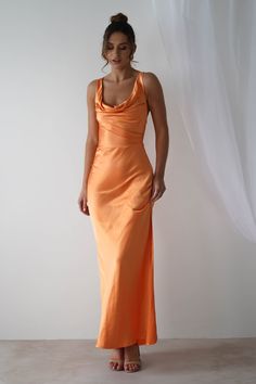 a woman in an orange dress poses for the camera