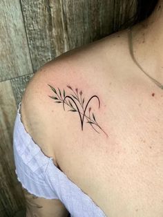 a woman with a small tattoo on her shoulder and arm, showing the outline of two flowers