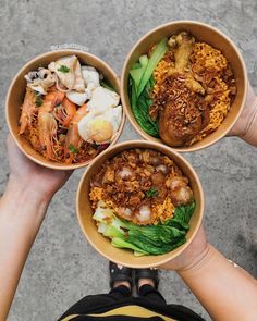 three bowls filled with food sitting on top of a cement floor next to each other