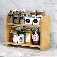 a wooden spice rack with spices and condiments in it on a marble countertop