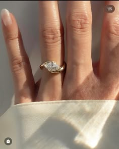 a woman's hand with a diamond ring on it