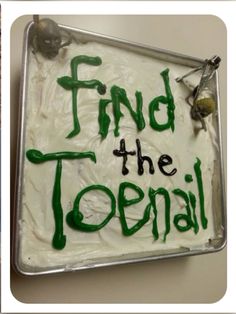 a cake with green frosting and writing that says find the toenail on it