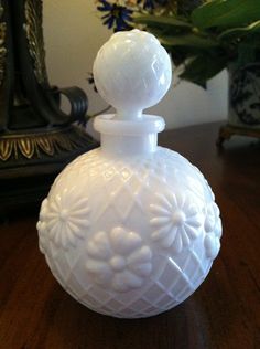 a white vase sitting on top of a wooden table