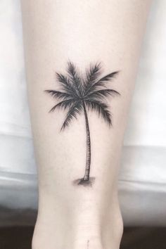 a small palm tree tattoo on the right side of the foot, which is black and white