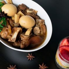 a white bowl filled with food next to a drink