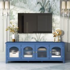 a blue entertainment center in front of a wall with a large screen tv on it