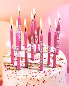 a birthday cake with pink candles and confetti sprinkles on it