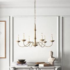 a chandelier hanging from the ceiling in a room with white walls and furniture