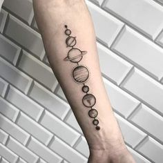 an arm tattoo with the planets on it