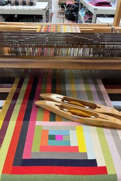 a pair of scissors sitting on top of a table next to a weaving loom