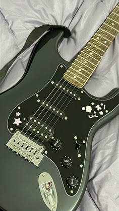 an electric guitar laying on top of a bed