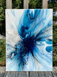 a blue and white painting sitting on top of a wooden table