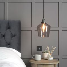 a bedroom with grey walls and a gray headboard on the side table next to a bed