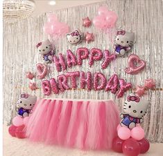 a hello kitty birthday party with pink tulle skirt and balloon decorations, balloons and streamers