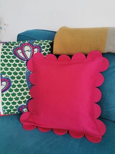 three pillows on a blue couch in a room